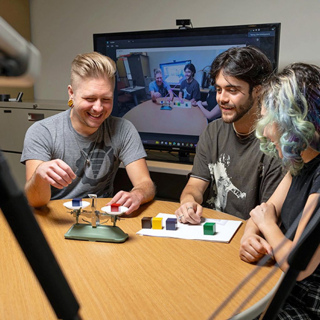 Students performing a simple block stacking task in front of cameras training an AI model